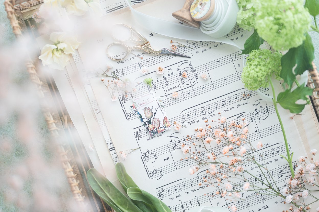 Overhead Shot of Flowers on a Music Sheet